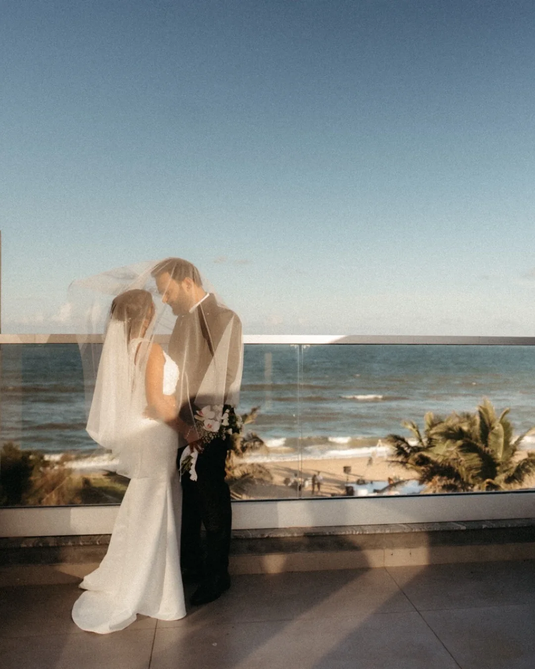 A newlywed couple embracing beside the sea